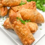 A stack of the finished dish on a square white plate.