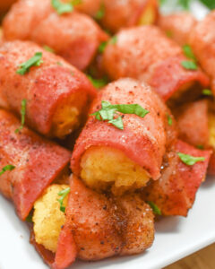 Bacon-wrapped tater tots on a white plate.