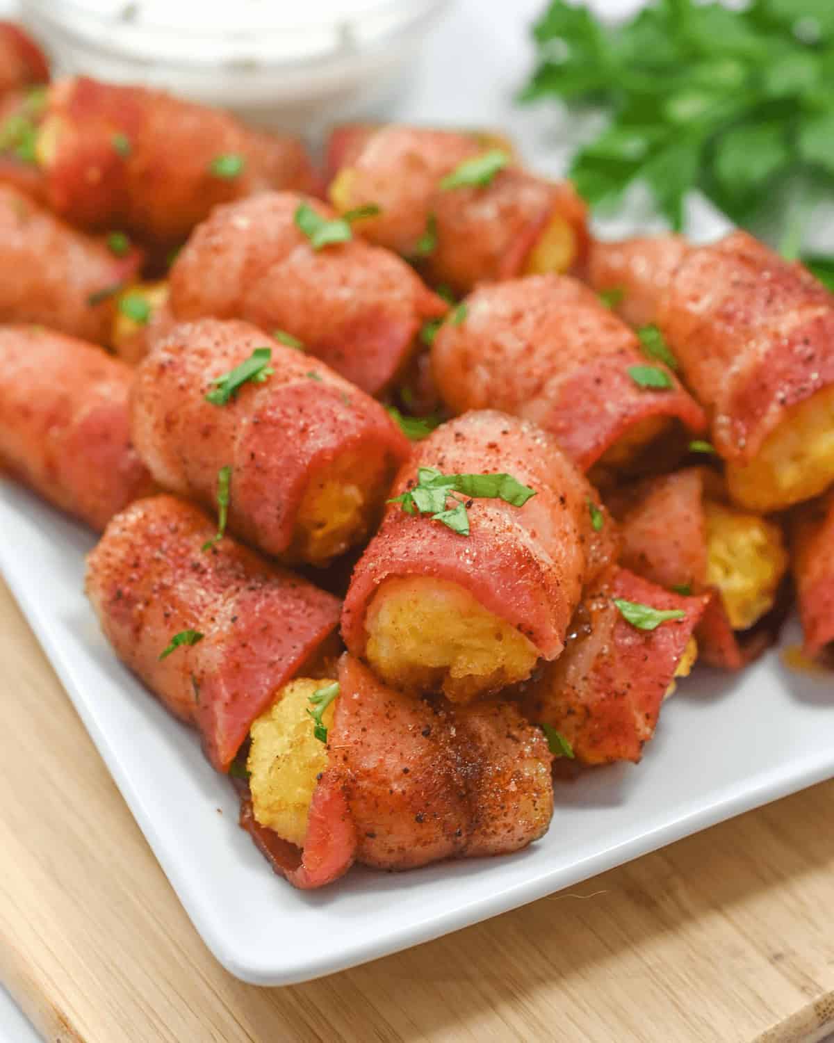 Bacon-wrapped tater tots on a white plate.