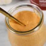 Boom Boom sauce in a glass jar with a spoon