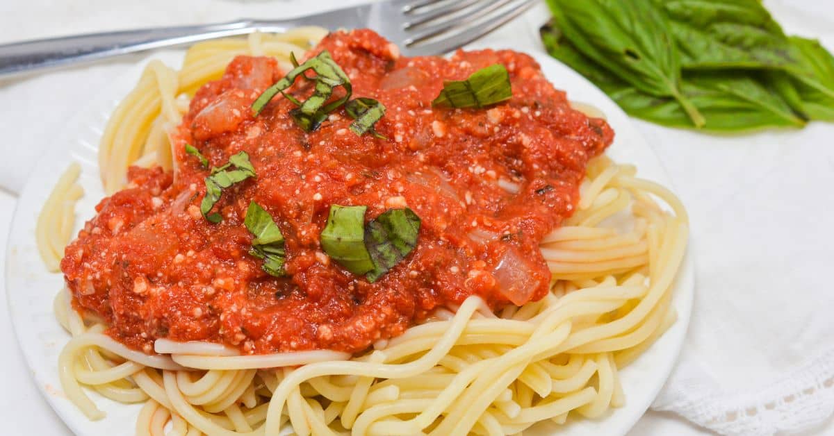A plate of spaghetti covered in hearty marinara sauce.