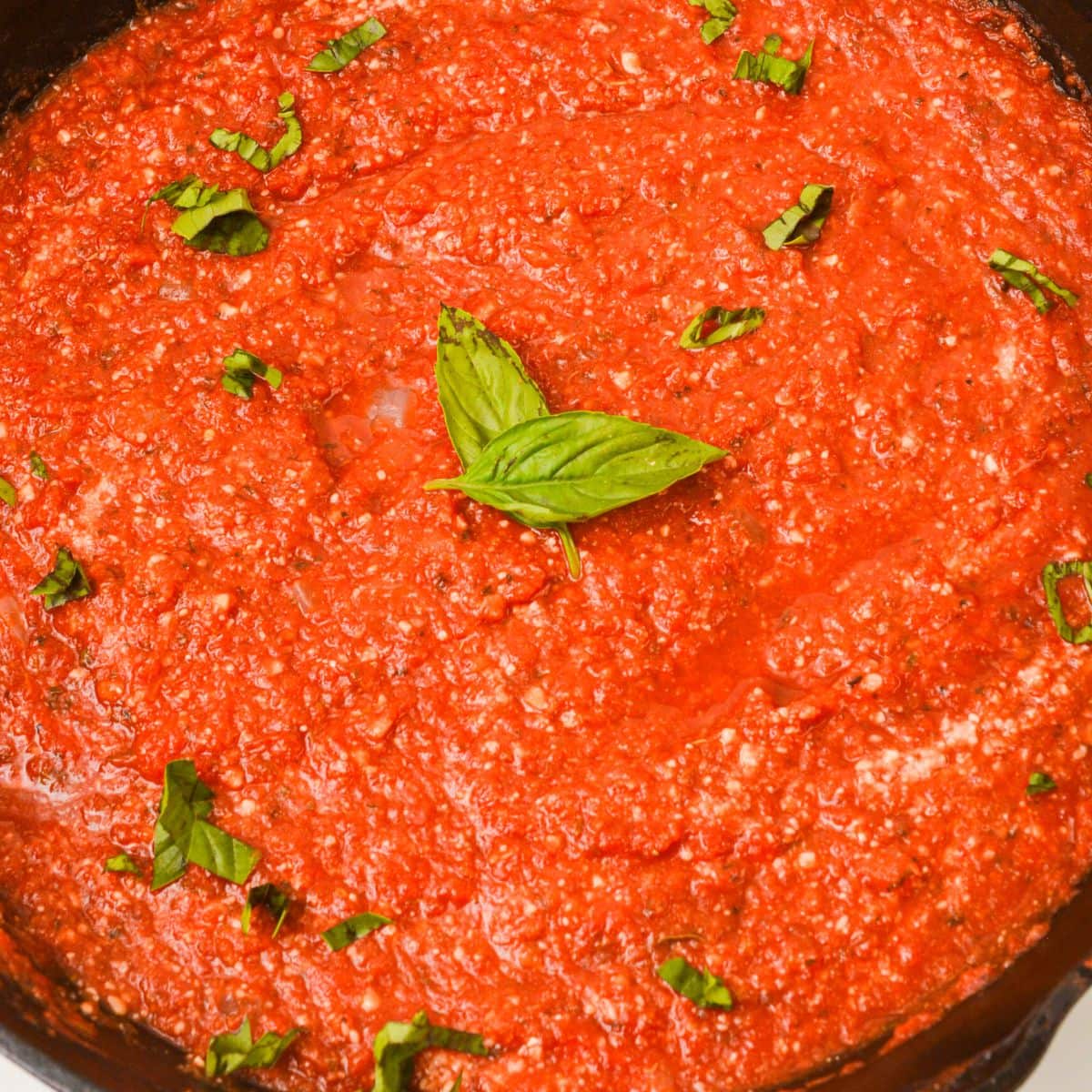 A close-up  in a pan, garnished with fresh basil leaves.