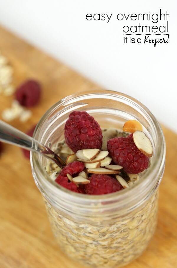 oatmeal topped with raspberries and almonds inside of a mason jar