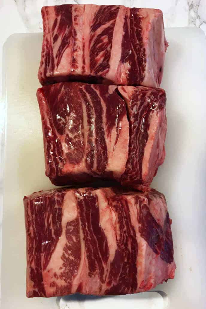 Raw beef short ribs on a cutting board