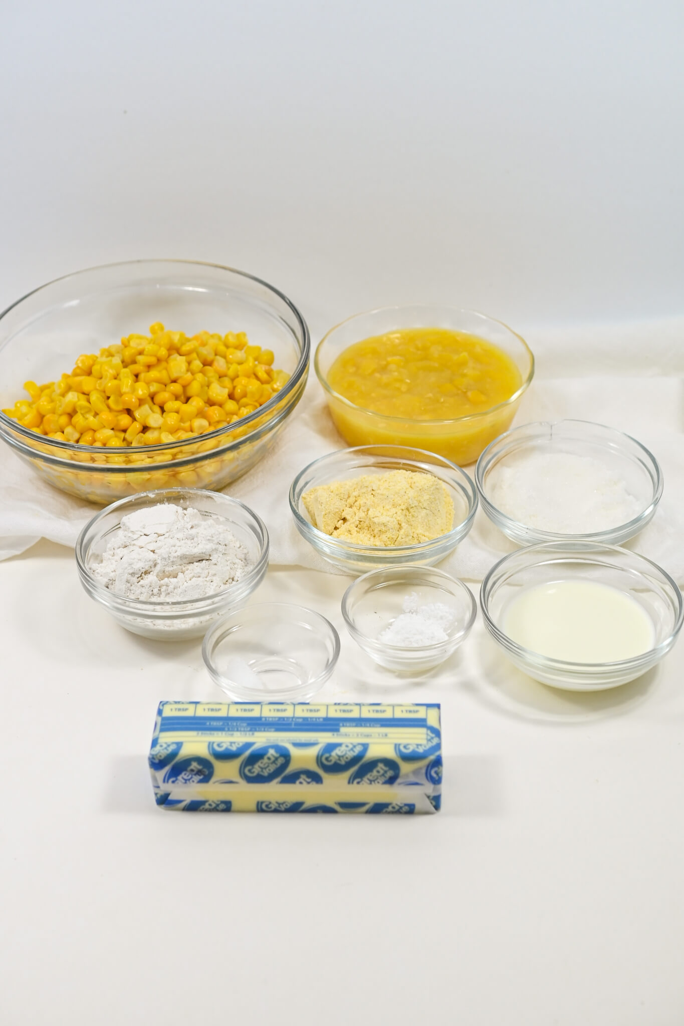 Ingredients for a Mexican Corn Cake recipe laid out on a table, including corn, flour, and butter.