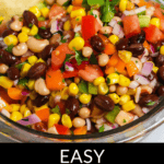 A colorful bowl of Redneck Caviar made with black-eyed peas, corn, diced tomatoes, onions, and peppers, garnished with cilantro and served with tortilla chips.