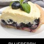 A slice of Blueberry Cream Pie topped with fresh blueberries and a mint sprig, served on a white plate.