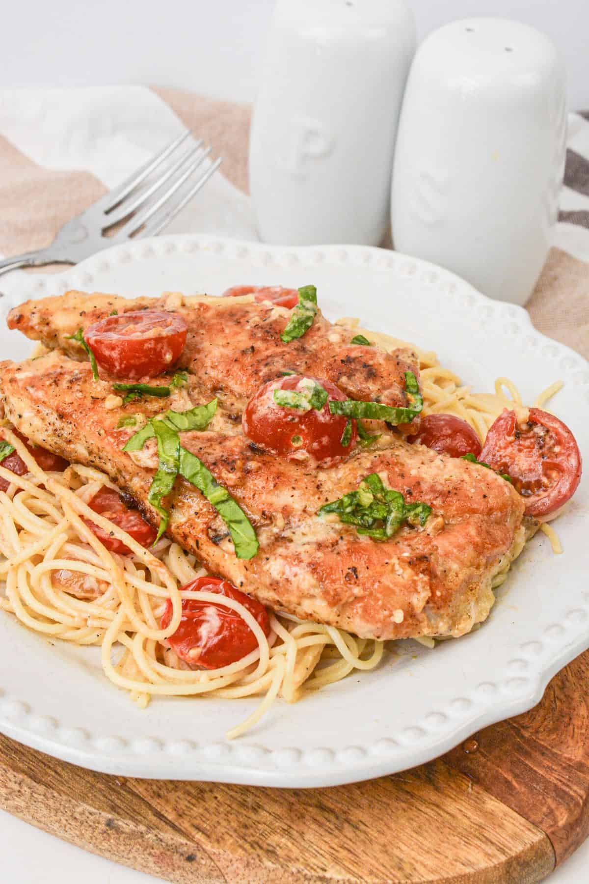 A white plate with chicken margherita on it.