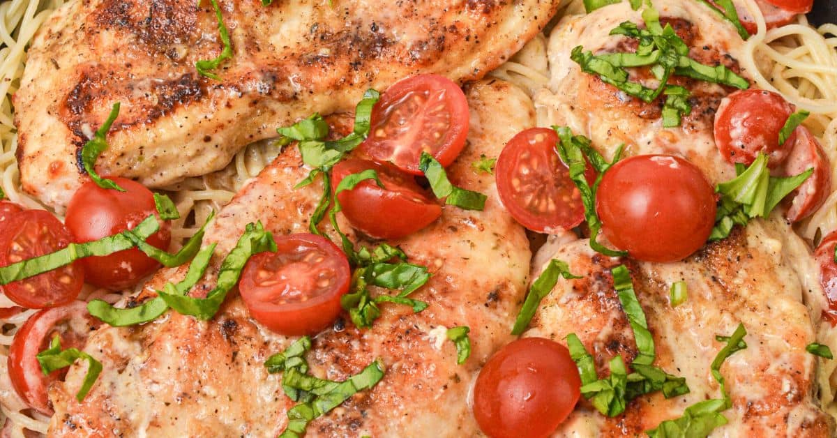 A close view of the finished Italian dish with tomatoes and fresh herbs.