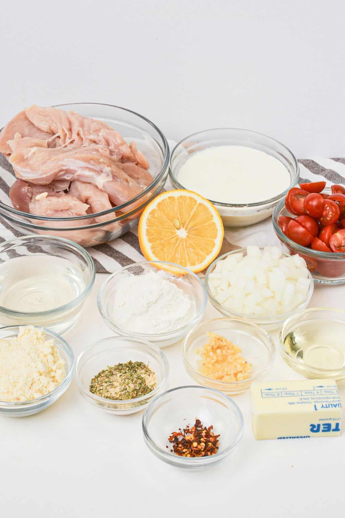 The fresh meat, lemons, tomatoes and herbs needed for the dish.