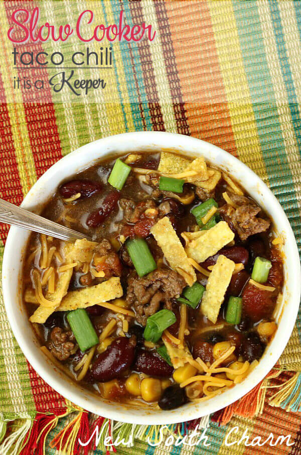 Slow Cooker Taco Chili in a white bowl, with a metal spoon on a multi colored place-mat. 
