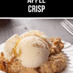 A serving of Crock Pot Apple Crisp topped with a scoop of vanilla ice cream on a white plate. Two forks are nearby.