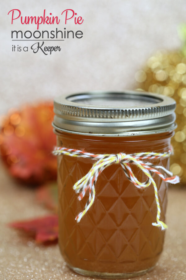 Pumpkin Pie Moonshine in a mason jar with leaves in the background.