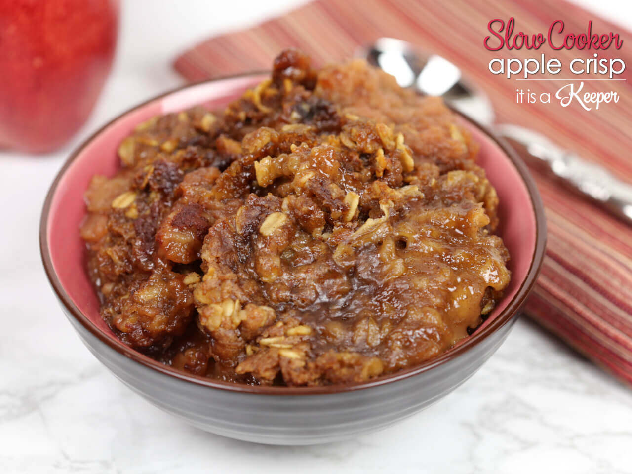 Slow Cooker Apple Crisp in a black bowl with red interior