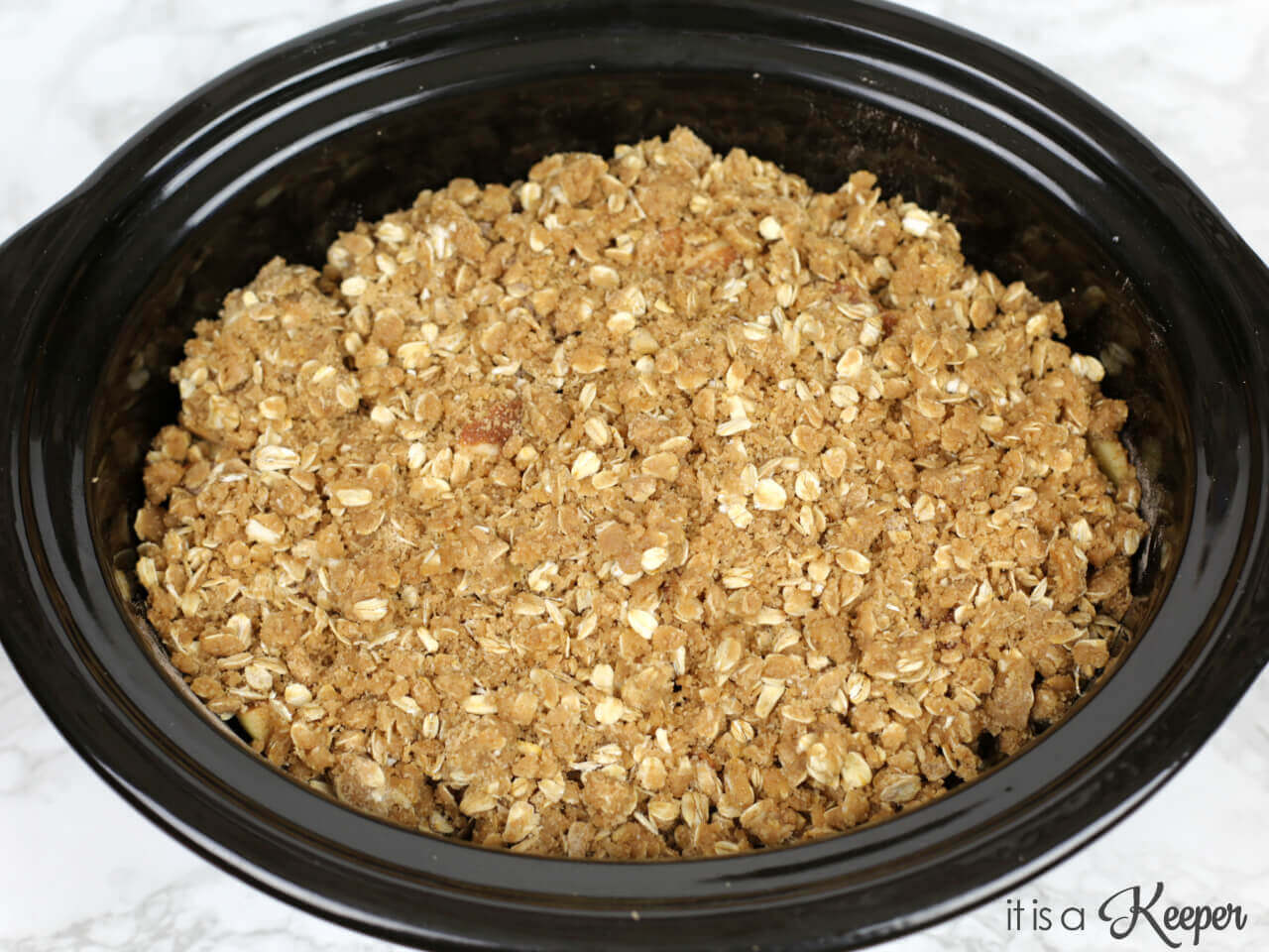 apples covered with granola in a slow cooker