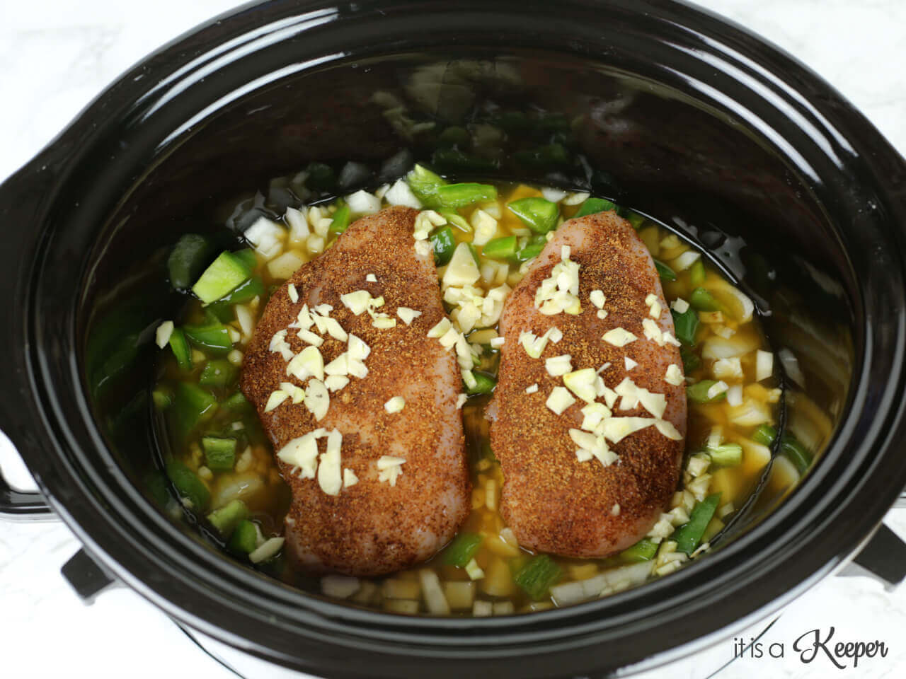 Two seasoned chicken breasts in a slow cooker, in a chick shock mixture.