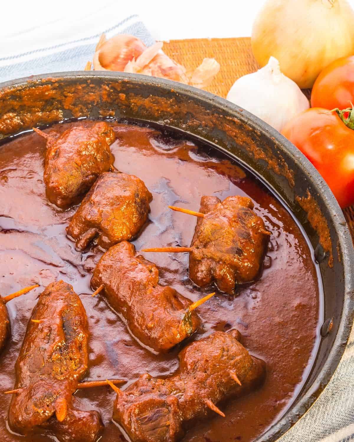 Meat cooked in a pan with tomatoes.