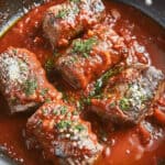Italian braciole in tomato sauce cooked in a skillet.