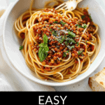 A bowl of spaghetti topped with a lentil tomato sauce and garnished with basil leaves, accompanied by a text overlay stating "easy lentils and pasta.