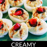 A plate of deviled eggs without mayo, garnished with red toppings and sprinkled with spices.