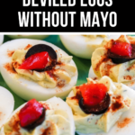 Creamy deviled eggs without mayo, topped with paprika and red garnish.