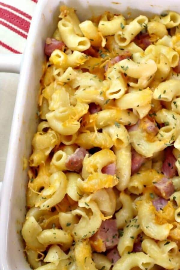 Close up on white baking dish of mac and cheee with ham