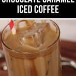 A glass of caramel iced coffee with chocolate, topped with ice cubes, and a red-striped straw.