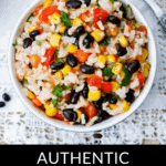 A bowl of rice mixed with black beans, corn, tomatoes, and green herbs. Text below reads "Mexican Rice and Beans." Fork on the side.