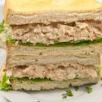 A multi-layered chipotle chicken salad sandwich with lettuce on white bread.