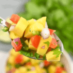 A colorful spoonful of mango salsa.