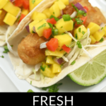 Fish tacos topped with mango salsa and a chipotle chicken salad on the side.