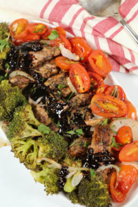 Balsamic Chicken Sheet Pan Recipe on a white platter with a pink and white napkin and fork