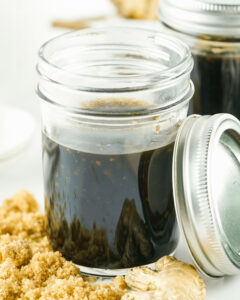 Glass jars containing homemade honey teriyaki sauce.