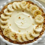 A banana cheesecake surrounded by slices of banana.