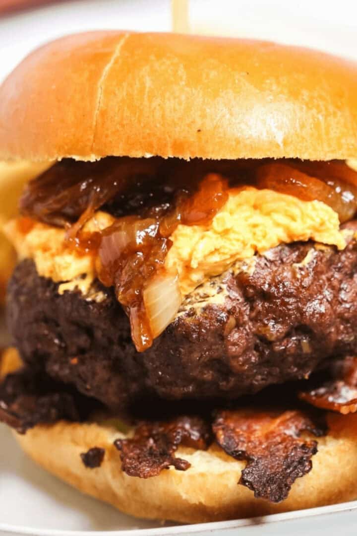 A thick pub burger on a white plate.