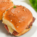 A close up of roast beef sliders with Dijon sauce.