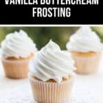 Three cupcakes topped with swirls from our Vanilla Buttercream Frosting Recipe are displayed, with one cupcake in focus on a doily and two blurred in the background.