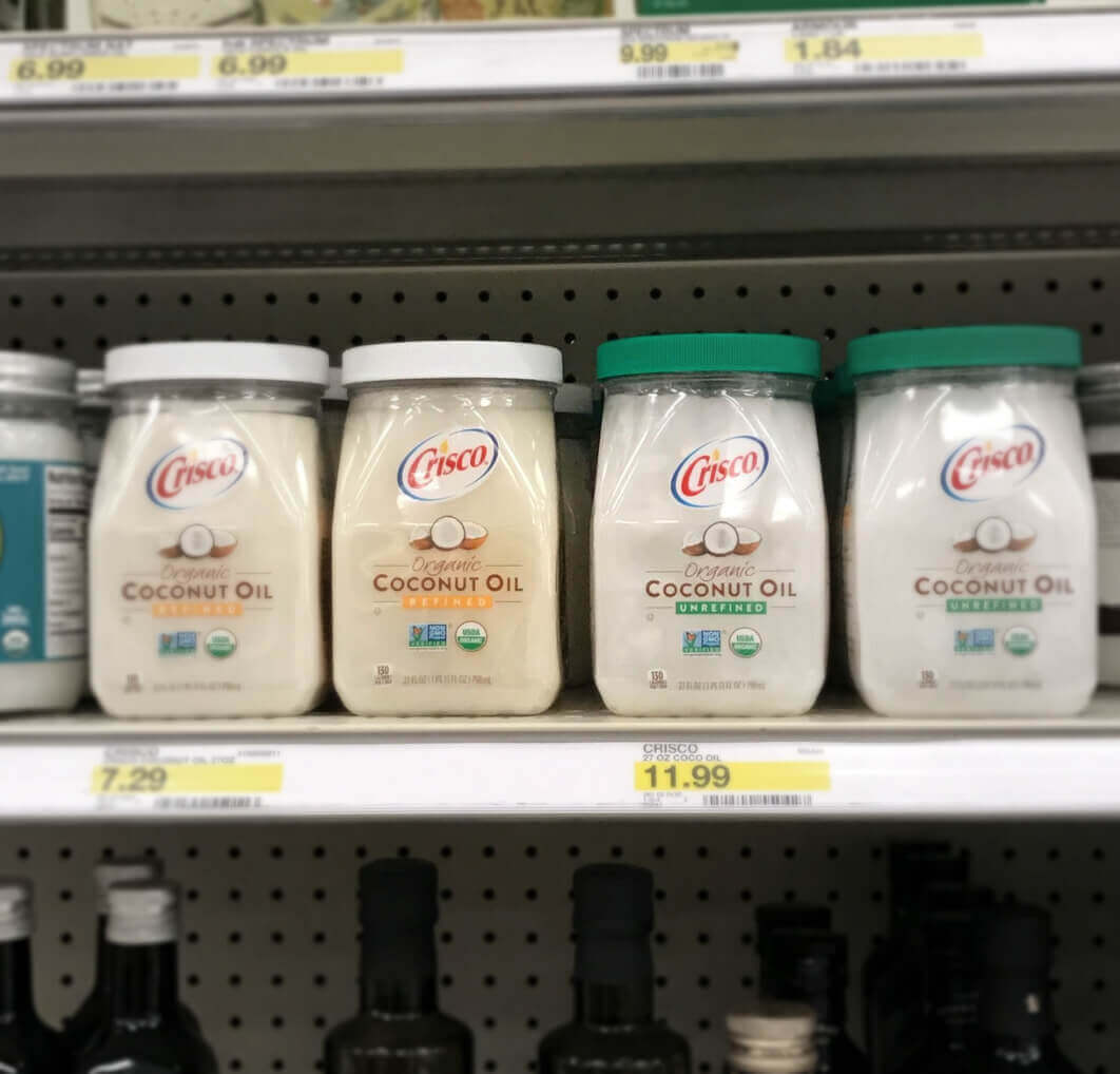 Jars of Crisco Coconut Oil on a white shelf.
