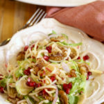 With layers of shaved brussels sprouts, apples, pomegranates, candied walnuts and a pomegranate vinaigrette, this fall harvest salad recipe is a winner!
