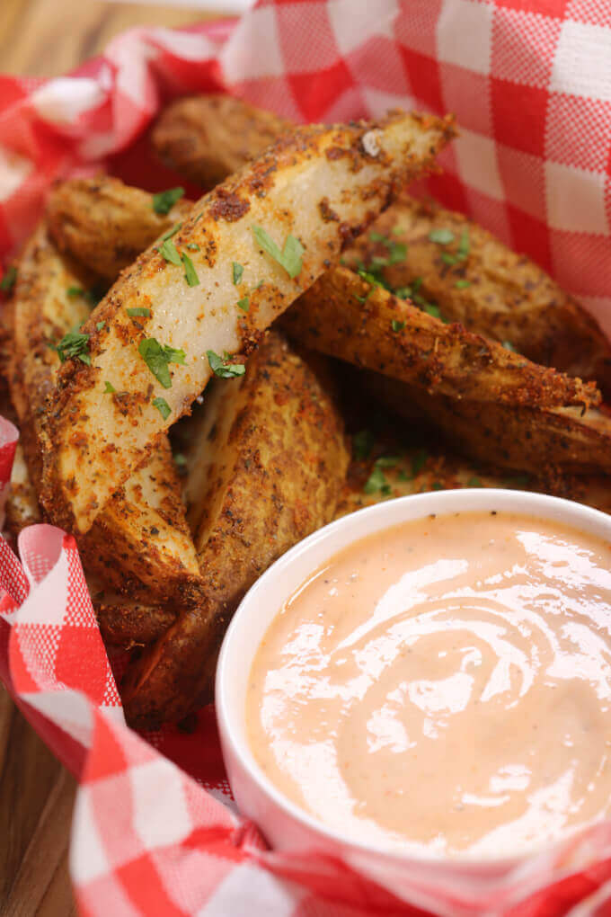 This Crispy Potato Wedges recipe is the perfect parter for burgers. They are made in the oven and oozing with flavor. 