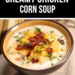 A bowl of creamy Chicken Corn Soup topped with shredded cheese, bacon, and chopped herbs sits on a beige cloth.