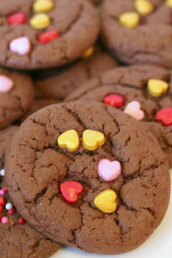 Chocolate cake mix cookies adorned with red, yellow, and pink heart-shaped sprinkles.