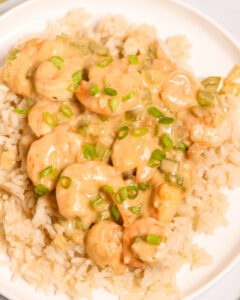 Creamy Garlic Shrimp and sauce over a bed of rice garnished with sliced green onions.
