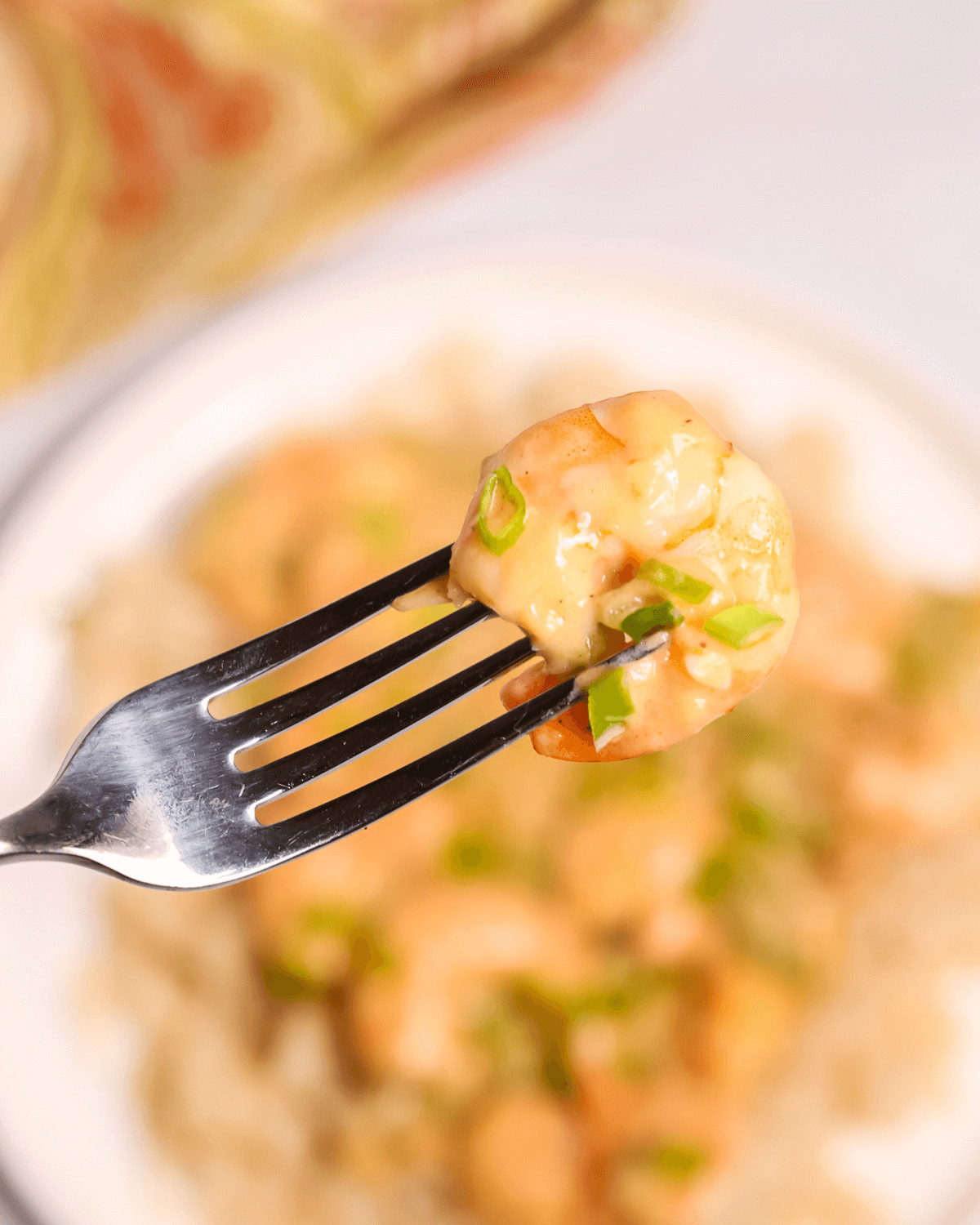 A fork of chopped green onions and creamy sauce.