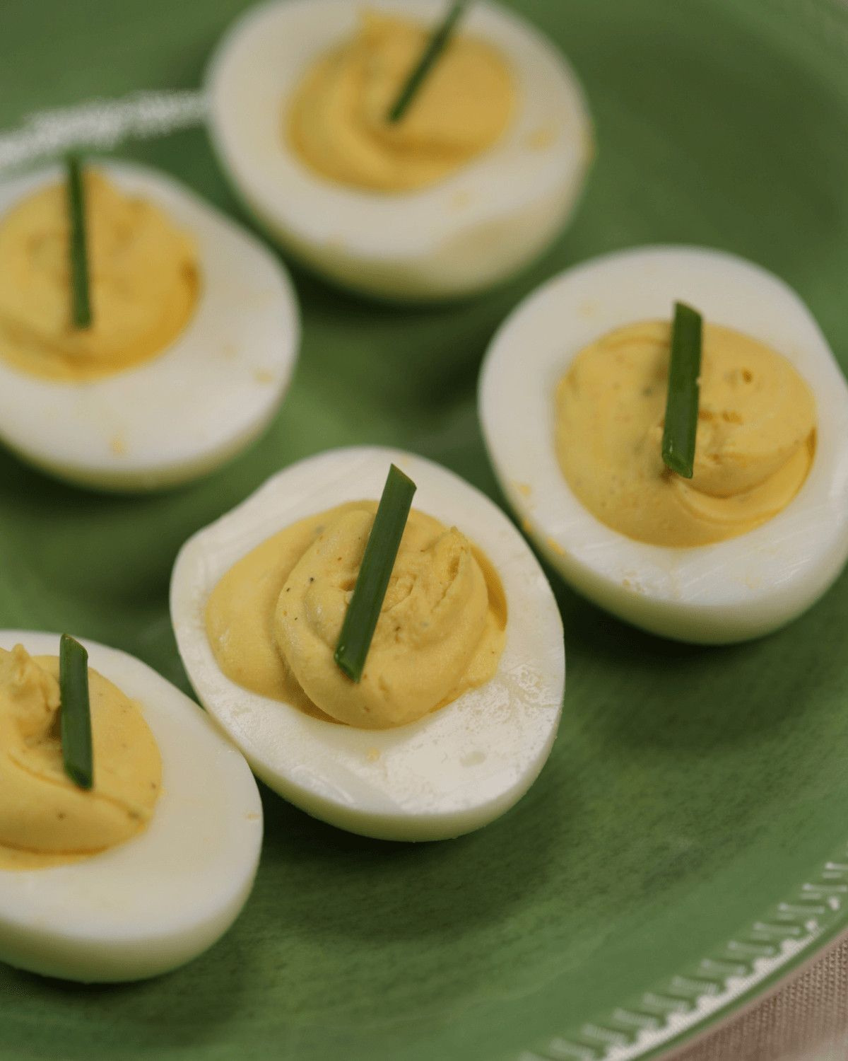 Platter of deviled eggs without mustard, garnished with chive strips.