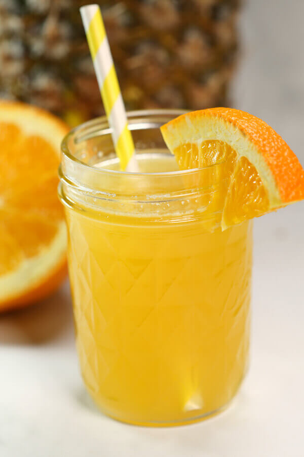 pineapple moonshine recipes topped with a slice of orange, served in a mason jar.