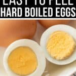 A plate with two whole brown eggs and two halves of a peeled hard-boiled egg. Text reads: "5 Ways for Easy to Peel Hard Boiled Eggs.