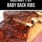 Succulent Instant Pot Baby Back Ribs generously glazed with sauce rest on a wooden board, artfully displayed upon a red and white checkered cloth.