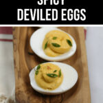 Sriracha spicy deviled eggs served on a wooden platter.