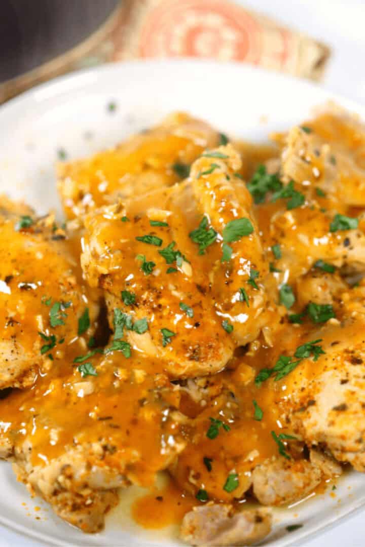 Instant Pot Bone In Chicken Thighs with Peri Peri Sauce on a white plate.
